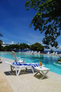 two chairs and a table next to a swimming pool at Almont Beach Resort in Surigao