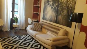 sala de estar con sofá y pintura en Appartamento in centro storico, en Asti