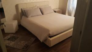 1 cama con sábanas blancas y almohadas en una habitación en Appartamento in centro storico, en Asti