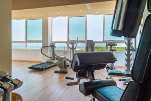 a gym with several treadying machines in a room with windows at Hotel Montecarlo in Bibione