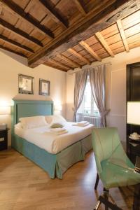 ein Schlafzimmer mit einem großen Bett und einem grünen Stuhl in der Unterkunft Relais Tosinghi in Florenz