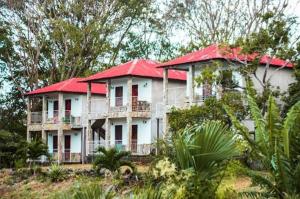 uma casa grande com um telhado vermelho numa colina em El Mirador Ecológico, Ometepe em Altagracia