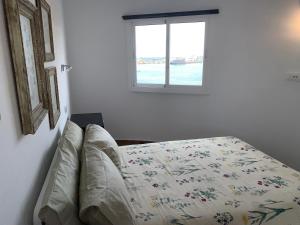 Ce lit se trouve dans un dortoir blanc doté d'une fenêtre. dans l'établissement Paseo Marítimo, Los Cristianos Over the sea FREE WIFI, à Arona