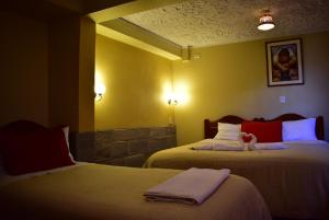 Giường trong phòng chung tại Kuska Hostal