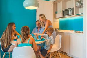 a group of people sitting around a table in a kitchen at Hotel Montecarlo in Bibione