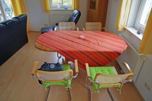 a dining room table with chairs and a red table at Bernsteinhaus Wohnung Usedom in Kolpinsee
