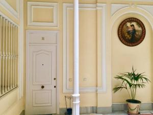 a hallway with a white door and a plant at La Casa de María Castaña in Seville +19 photos