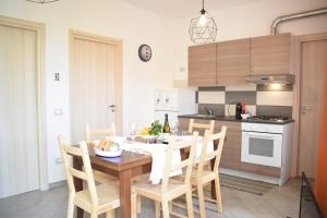 a kitchen with a wooden table and chairs and a kitchen with at Kitesurf lo Stagnone in Marsala
