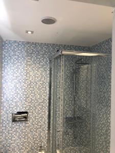 Łazienka z prysznicem wyłożona jest niebieskimi kafelkami. w obiekcie Aurora Sirmione Appartamenti w Sirmione