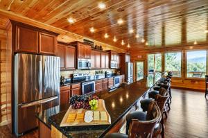 una cocina con una barra larga con sillas. en Foxwood Mansion Cabin, en Pittman Center