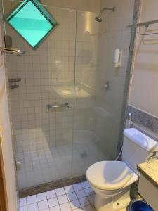 ein Bad mit einer Glasdusche und einem WC in der Unterkunft Marulhos Resort Flat E205 in Porto De Galinhas