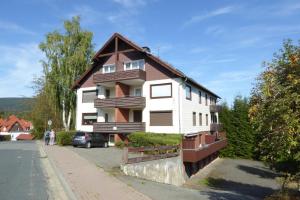 une maison blanche et brune sur le côté d'une rue dans l'établissement Bergblick-Braunlage, à Braunlage