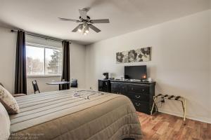 - une chambre avec un lit et un ventilateur de plafond dans l'établissement Auberge motel drakkar, à Shawinigan
