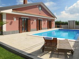 a swimming pool with a chair next to a house at VILLA VITTORIA in Pedara