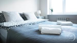 a blue bed with white towels on top of it at Apartament Siódemka in Pisz
