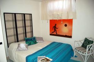 una camera da letto con un letto, una sedia e un quadro di Apt. Marilena by SolturElba a Capoliveri