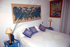 una camera da letto con un letto con cuscini blu e bianchi di Apt. Marilena by SolturElba a Capoliveri