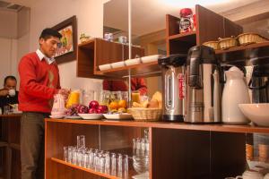 un hombre de pie en una cocina preparando comida en Kaaro Hotel Puno, en Puno