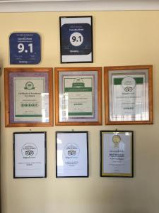 a group of framed certificates on a wall at Camellia Motel in Narrandera