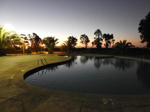 una piscina in un parco con un tramonto sullo sfondo di Agradable Casa en Condominio Prados del Mar Tongoy a Tongoy