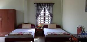 Habitación con 2 camas y ventana en Hai Dang Hotel, en Châu Làng Chánh