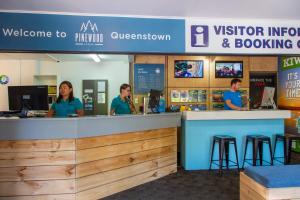 a group of people sitting at a counter at Pinewood Lodge and Apartments in Queenstown