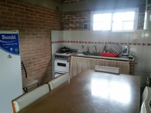 a kitchen with a table and a stove and a window at Casa de Vero in Mina Clavero +12 photos