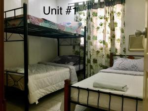 een slaapkamer met 2 stapelbedden en een raam bij 2bedroom apartment near CONVENTION center in Iloilo City
