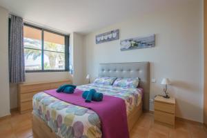 ein Schlafzimmer mit einem Bett mit einer lila Decke in der Unterkunft Paraiso 1 Sea view - TENESOL RENTALS in Playa Paraiso + 24 Fotos