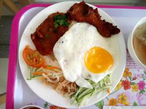 un piatto di cibo con un uovo e carne di Hung Long Hotel a Ben Tre