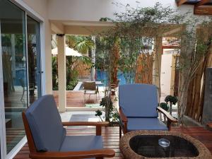 - une terrasse avec 2 chaises et une table basse dans l'établissement Ayara Villas - SHA Extra Plus, à Khao Lak