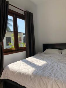 a bedroom with a bed and a window at Bí Homestay in Mui Ne