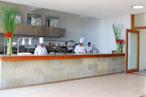 un gruppo di chef in piedi dietro un bancone in cucina di Almont Beach Resort a Surigao