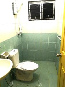 łazienka z toaletą i umywalką w obiekcie Izzanial Homestay w mieście Sandakan