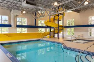 a swimming pool with a slide in a building at Microtel Inn & Suites by Wyndham Oyster Bay Ladysmith in Ladysmith