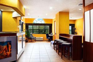 un restaurante con paredes amarillas y un bar con taburetes en Microtel Inn & Suites by Wyndham New Braunfels I-35 en New Braunfels