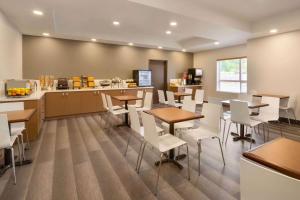 a restaurant with tables and chairs and a counter at Microtel Inn & Suites by Wyndham Oyster Bay Ladysmith in Ladysmith