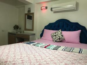 1 cama con cabecero azul y almohadas rosas en Invivo Hotel, en Izmir