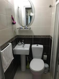 a bathroom with a toilet and a sink and a mirror at Invivo Hotel in İzmir