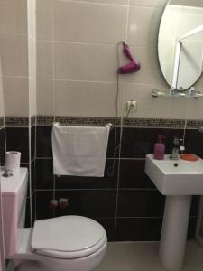 a bathroom with a toilet and a sink and a mirror at Invivo Hotel in Izmir