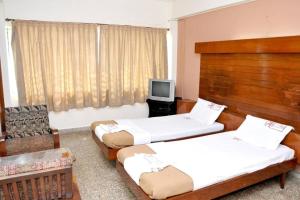 Postel nebo postele na pokoji v ubytování PRANAM COMFORTS LODGE