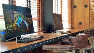 a desk with a computer monitor and a keyboard and mouse at Aurico Kata Resort & Spa - SHA Extra Plus in Kata Beach