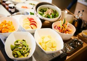a table topped with bowls of different types of food at Hotel Intergate Kanazawa in Kanazawa