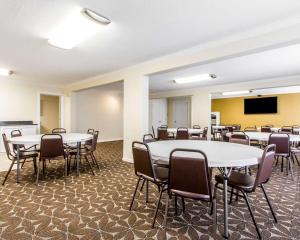 a room with tables and chairs and a flat screen tv at Mill Tree Inn Millington in Millington