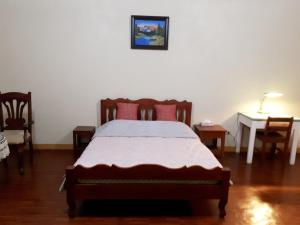a bedroom with a bed and a table and chairs at Minine Guesthouse in Silang