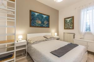 a white bedroom with a bed and two lamps at Sweet Home Bologna in Bologna