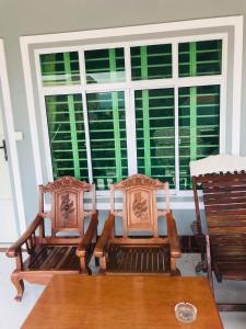 two chairs and a table in front of a window at KampongBay Makeng II Guesthouse in Kampot