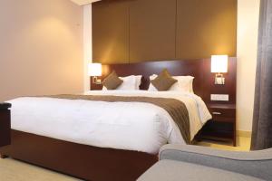 ein Hotelzimmer mit 2 Betten mit weißer Bettwäsche in der Unterkunft Visthara inn - Comfort Stay in Krishnagiri