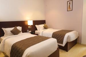 Postel nebo postele na pokoji v ubytování Visthara inn - Comfort Stay