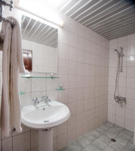 a white bathroom with a sink and a shower at Hotel Sigma in Kiten